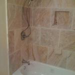 NEW STEEL ENAMEL WHITE TUB WITH 18X18 TRAVERTINE AND BRUSED NICKEL DELTA FAUCET