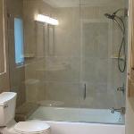 BATHTUB REMODEL FROM OLD CAST IRON TUB TO NEW BOOTZ CAST STEEL WITH BRUSHED NICKEL FAUCET, REAR BENCH/SHELF AND CUSTOM GLASS PIVOT DOOR ALSO USED 18X18 TILE