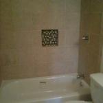 NEW AMERICAN STANDARD PRINCETON TUB WITH 12X12 CERAMIC TILE, DELTA VALVE IN CHROME AND RECESS BOX WITH GLASS TILE BACKROUND